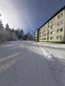 a snow covered street in front of a building at Ferienwohnung Waldblick Oberhof in Oberhof