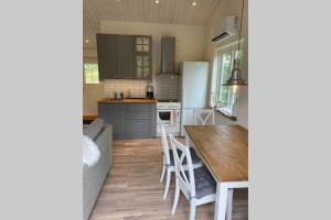 cocina con mesa de madera y cocina con nevera en Cottage perfect for short time rent, en Gustavsberg