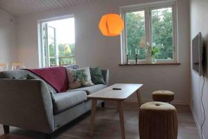 uma sala de estar com um sofá e uma mesa em Cottage perfect for short time rent em Gustavsberg