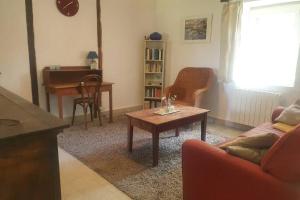 ein Wohnzimmer mit einem Sofa, einem Tisch und einem Klavier in der Unterkunft obouduchemin in Cindré