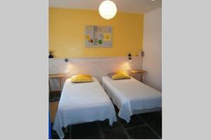 2 camas en una habitación con paredes amarillas en obouduchemin, en Cindré
