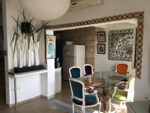 a dining room with a glass table and chairs at Jasmin 4 in Netanya