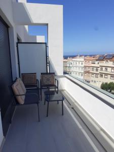 balcón con 2 sillas y ventana grande en Atico Casa Kyara, con gran Terraza y Parking, Iceberg Albacerrado, en Tarifa