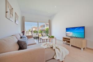 sala de estar con sofá y TV de pantalla plana en Villa Mar, en Alcudia