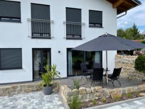 patio con tavolo e ombrellone di Ferienwohnung Matzing 