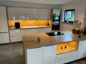 a kitchen with white cabinets and a wooden counter top at Ferienwohnung Matzing 