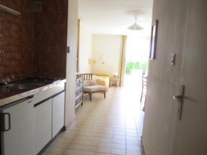 a kitchen with white appliances and a living room at Motel Saint Francois in Calvi