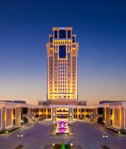 um grande edifício com um monte de luzes sobre ele em Divan Erbil Hotel em Arbil
