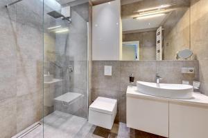a bathroom with a sink and a toilet and a shower at Luxury Bianco Apartament in Sopot +19 photos