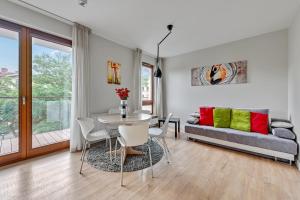 a living room with a table and a couch at Luxury Bianco Apartament in Sopot