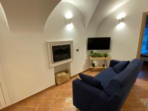 a living room with a blue couch and a tv at Holiday Home Falchetta in Palena