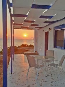 阿漢涅羅斯的住宿－Sea View Holiday House，一个带桌椅的庭院,享有日落美景
