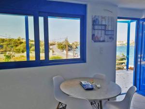 a table and chairs in a room with a view of the ocean at Sea View Holiday House in Archangelos