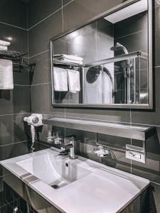 y baño con lavabo blanco y espejo. en Hotel Kompleksi Arifi, en Shkodër
