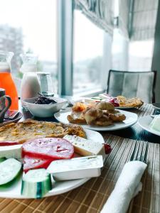 una mesa de madera con platos de comida. en Hotel Kompleksi Arifi, en Shkodër