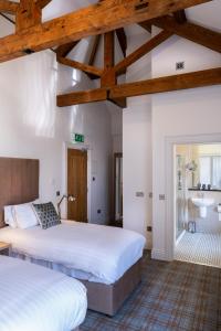 Duas camas num quarto com vigas de madeira em Markree Courtyard em Collooney