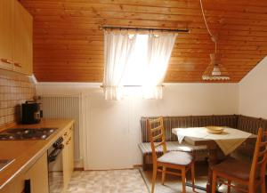 eine kleine Küche mit einem Tisch und einem Fenster in der Unterkunft Erd´s Hoimatle Ferienwohnung in Jungholz