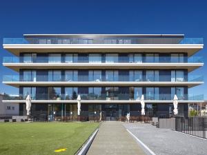a large building with a lawn in front of it at Hotel AVA in Sempach Station