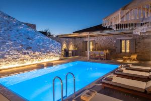 una piscina en una villa por la noche en 2a Villa en Mokhós