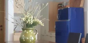 eine grüne Vase mit Blumen auf dem Tisch in der Unterkunft Stonehouse on the Hill in Murter