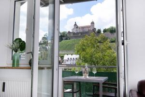 een balkon met een tafel en uitzicht op een kasteel bij Ferienwohnung Panorama mit Festungsblick in Würzburg