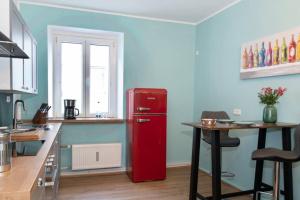 a red refrigerator in a kitchen with a table at Ferienwohnung Panorama mit Festungsblick in Würzburg