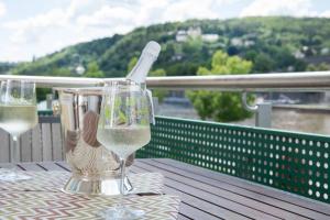 twee glazen wijn op een tafel op een balkon bij Ferienwohnung Panorama mit Festungsblick in Würzburg