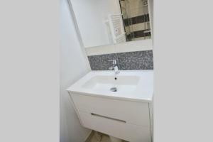 a bathroom with a white sink and a mirror at Les Forges studio étage in Avoine