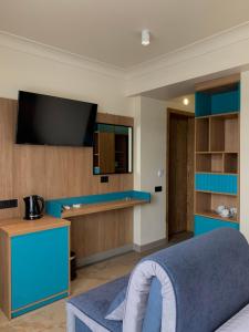 a living room with a tv and a blue couch at WindRose in Zatoka