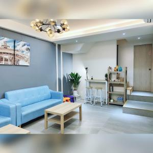 a living room with a blue couch and a table at NO.14 in Tainan