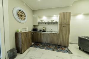 a kitchen with a sink and a clock on the wall at Corleone GUESTHOUSE in Corleone