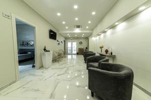 a waiting room with couches and chairs on a marble floor at Corleone GUESTHOUSE in Corleone