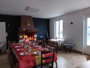 a dining room with a table and a fireplace at Le Moulin de la Planquette in Cavron-Saint-Martin