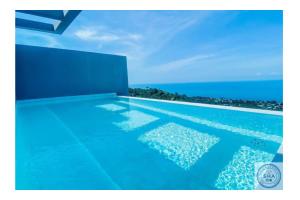 una piscina con el océano en el fondo en Panorama Samui Residences en Ban Bang Po