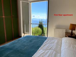 a bedroom with a bed and a view of a balcony at Casa al Campanile, LeonardosHome in Trarego