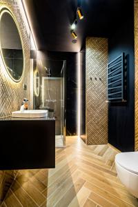 a bathroom with a tub and a sink and a mirror at BanApart Exclusive Apartments in Zgorzelec