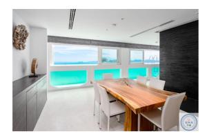 une salle à manger avec une table en bois et des chaises blanches dans l'établissement Panorama Samui Residences, à Ban Bang Po