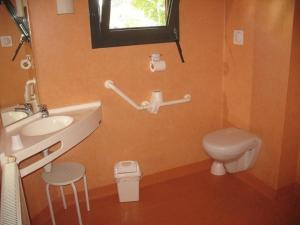 a bathroom with a sink and a toilet and a window at HOME DU BUISSON Hôtel des Familles in Isle