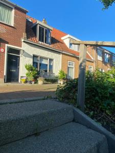 a brick house with a staircase in front of it at Huisje Vogelenzang Zeeland in Sint Annaland