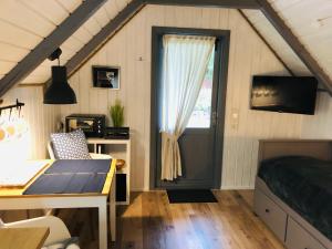 ein Schlafzimmer mit Bett, Schreibtisch und Fenster in der Unterkunft Ferienhaus Vogelkoje in Emmelsbüll-Horsbüll