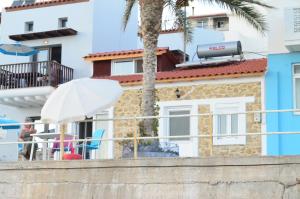 un edificio con una palmera y un paraguas blanco en Myrtos Harmony Apartments, en Myrtos