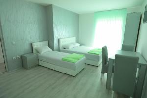 Habitación con 2 camas, sofá y ventana en Bovan GREEN LAKE apartments en Soko Banja