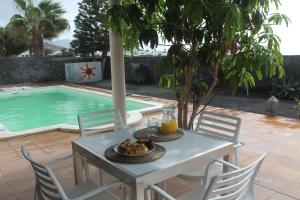 a table and chairs next to a swimming pool at VILLA RAQUEL in Yaiza