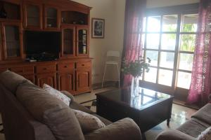 a living room with a couch and a tv at VILLA RAQUEL in Yaiza