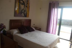 a bedroom with a bed and a window at VILLA RAQUEL in Yaiza +8 photos