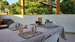 a table with a white table cloth and pitchers on it at Meraviglia d'Otranto in Otranto