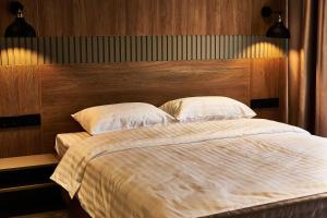 a bedroom with a large bed with a wooden headboard at WindRose in Zatoka
