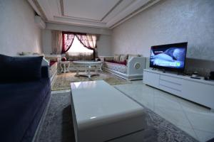 - un salon avec un canapé et une télévision dans l'établissement appartement 69 vue sur mer 3 chambre, à Tanger
