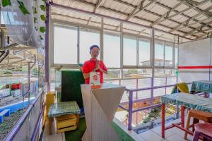 a man is standing at a counter in a room at OYO 90352 Villa Agape 2 in Cianjur