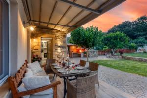 un patio al aire libre con mesa y sillas en Villa 4 DESTINA, en Élos